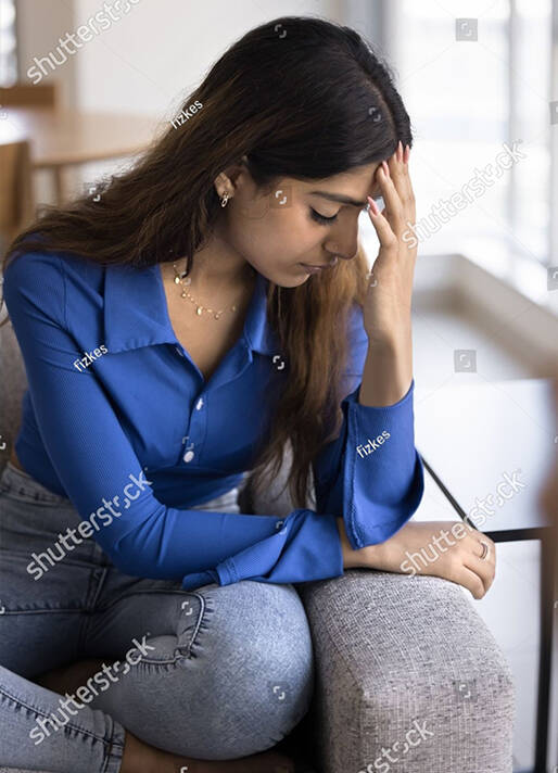 Woman sitting alone, looking weary and overwhelmed