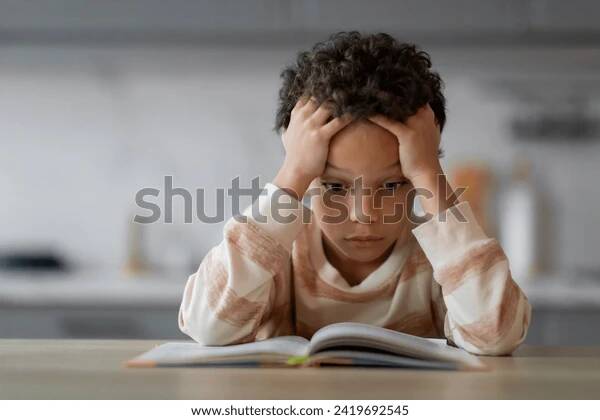 Child sitting quietly, looking thoughtful and withdrawn