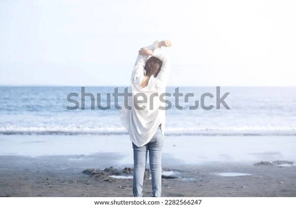 Person standing in sunlight, looking peaceful and free